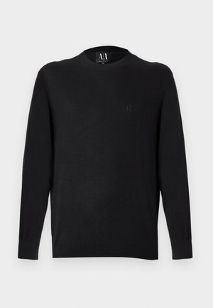 Jersey negro de punto con mangas largas, cuello redondo y puños acanalados. Presenta un logo bordado en el pecho. Textura suave.