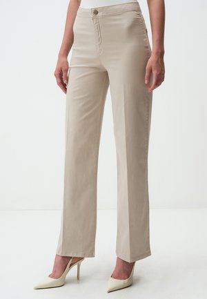 Beige straight-leg trousers made of cotton blend, featuring a smooth texture and front button closure, paired with white pointed heels.