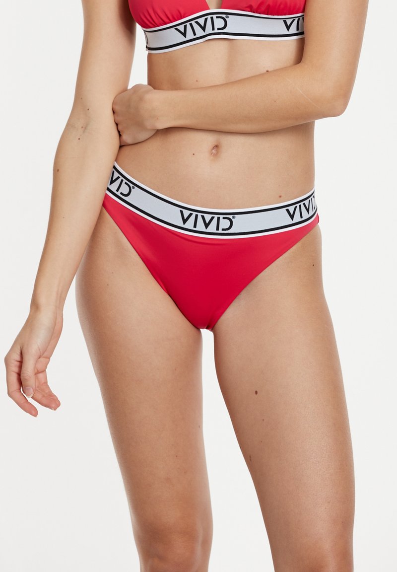 Červené bikiny s trojúhelníkovým vrškem a nízko výkopaným spodním dílem. Na pase mají bílý pruh s nápisem "VIVID". Hladká textilie.