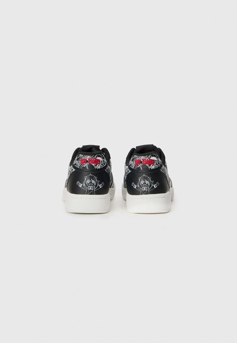 Baskets noires avec des motifs de personnages de dessin animé à l'arrière, dotées de semelles blanches et d'une marque rouge, sur fond blanc.