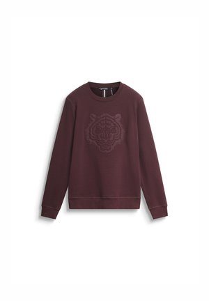 Bordo dukserica s podignutim grafičkim prikazom tigrove glave na sredini. Izrađena od mekog materijala, s dugim rukavima i rebrastim manžetama.