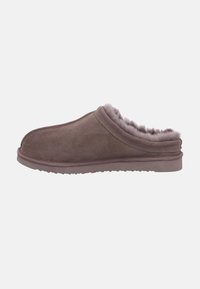 Bruna mockasiner i mocka med mjuk foder, låg profil, rund tå och texturerad gummisula. Detaljer inkluderar sydda sömmar.