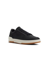 Zapatillas negras de cuero con punta redondeada, cordones planos y una entresuela blanca. Parte superior texturizada con una suela de goma color caramelo contrastante.