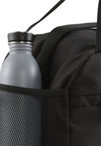 Black backpack with a side mesh pocket holding a gray metal water bottle. Features sturdy fabric and adjustable straps.