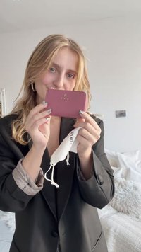 Furla cardholder in dark pink leather with gold logo, zip closure, and white drawstring pouch. Smooth texture and compact design.