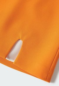 Tissu orange à la texture douce avec un détail découpé et des bords nets. Le matériau semble léger et lisse.