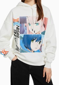 Vit hoodie med grafisk tryck som har två karaktärsillustrationer, accentuerad med blå och orange linjer, och en framficka.