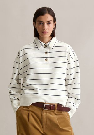 White striped sweatshirt with a collared neck and three buttons. Fabric has a smooth texture. Paired with brown corduroy pants and a brown belt.