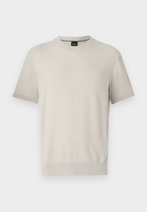 Kortärmad t-shirt med rund halsringning i ljusbeige texturerad tyg. Har ribbat halsringning och muddar med en diskret kontrasterande kant.