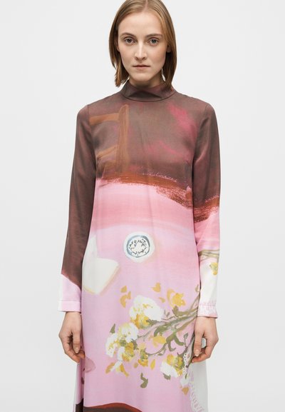 Ilgam rankovių suknelė iš minkštos medžiagos, puošta spalvingu abstrakčiu raštu, kuriame vyrauja rudos, rožinės spalvos atspalviai ir gėlių motyvai. Apykaklės imitacija prie kaklo.