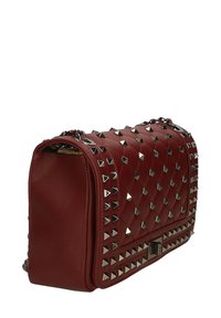 Borsa a tracolla in pelle trapuntata rossa con borchie argentate, forma rettangolare, tracolla a catena e chiusura a fermaglio. Superficie tessurizzata con dettagli curati.