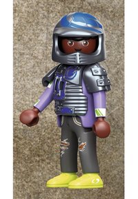 Action figure wearing a silver helmet, purple shirt with armor accents, black pants with rips, and yellow shoes. Features brown hands and hair.