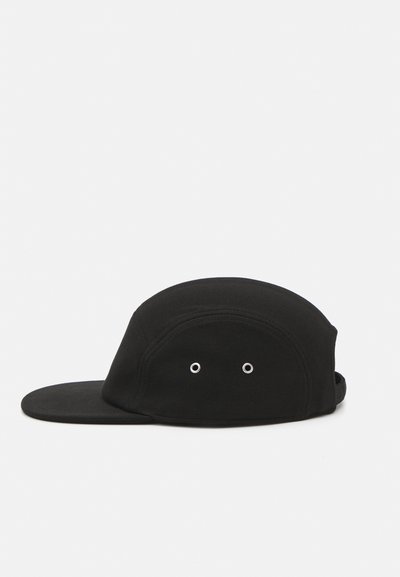 Casquette noire avec une couronne arrondie et une visière plate, dotée de deux œillets de ventilation à l'avant. Fabriquée en tissu texturé.