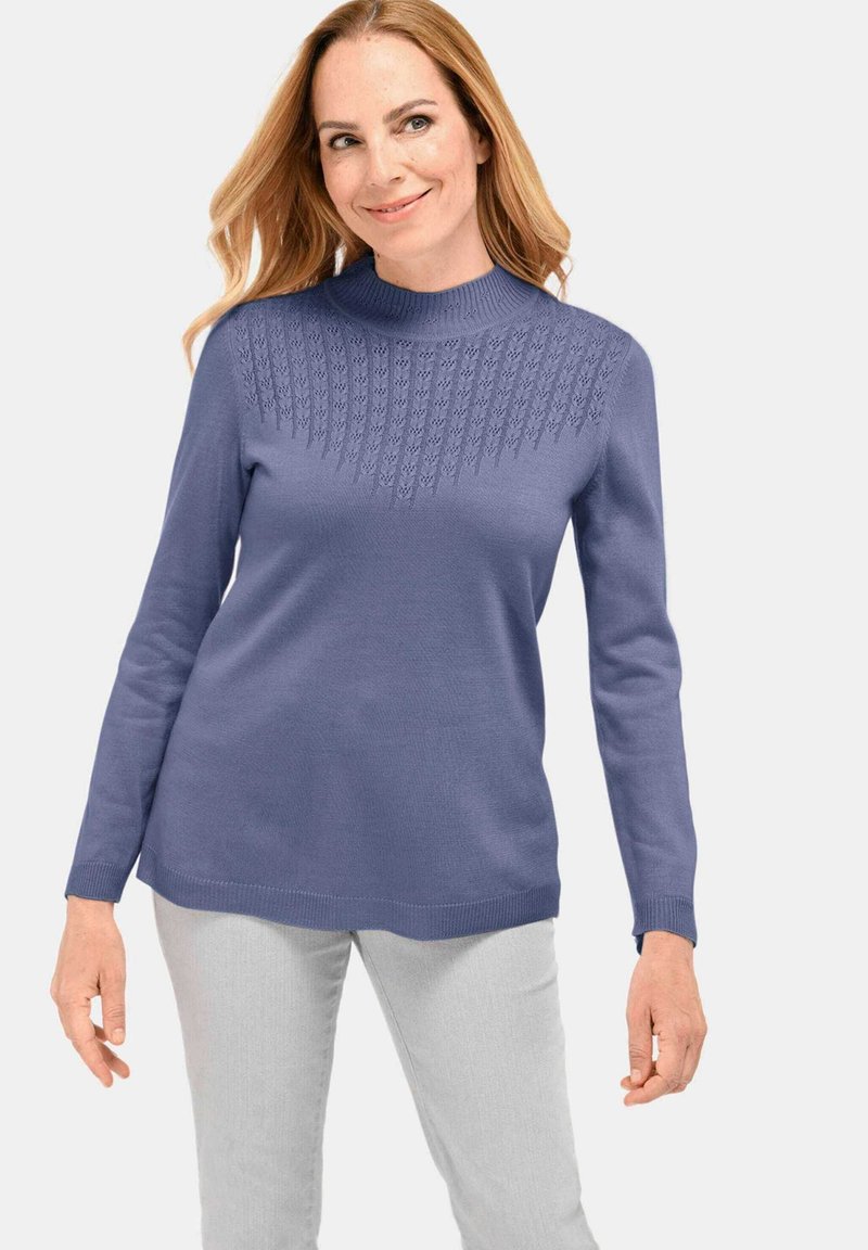 Pull à manches longues en doux violet clair avec un col montant. Présente un design tricoté texturé au niveau de la poitrine et un ourlet droit.