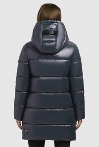 Cappotto invernale imbottito di un blu navy scuro con finitura lucida, dotato di un ampio cappuccio, cuciture orizzontali e una targhetta con logo vicino all'orlo.