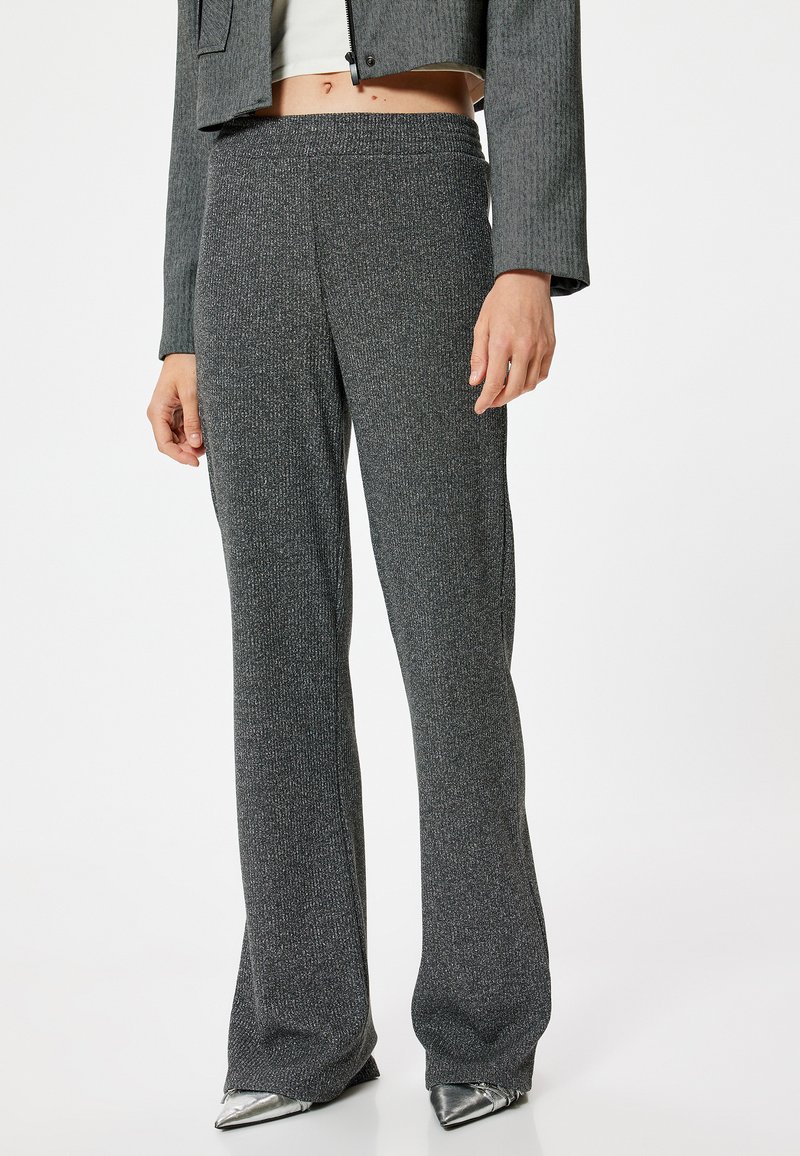 Pantalones grises texturizados de tiro alto con un diseño de pernera ancha. La tela tiene un suave brillo y una cinturilla elástica y suave.