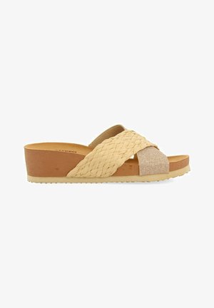 Sandalias deslizantes para mujer tejidas con un diseño beige, que presentan una correa cruzada y una suela de plataforma acolchada. Detalles texturizados en beige y dorado.