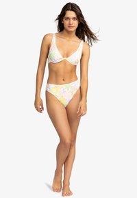 Blomsterprint bikini i lyse pastel farver. Overdelen har et trekantet design med brede stropper; underdelen har en høj talje og et matchende mønster.