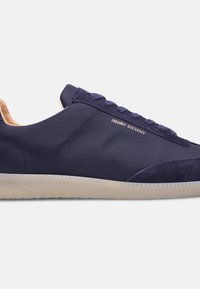 Dunkelblaue Sneaker mit einem strukturierten Obermaterial aus Stoff, Suede-Akzenten und einer weißen Gummisohle. Der Markenname "Henry Stevens" ist eingeprägt.