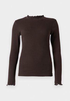 Bruine langslivige top van ribbelstof, met een ruches decolleté en manchetten. Het ontwerp is aansluitend met een gladde textuur.