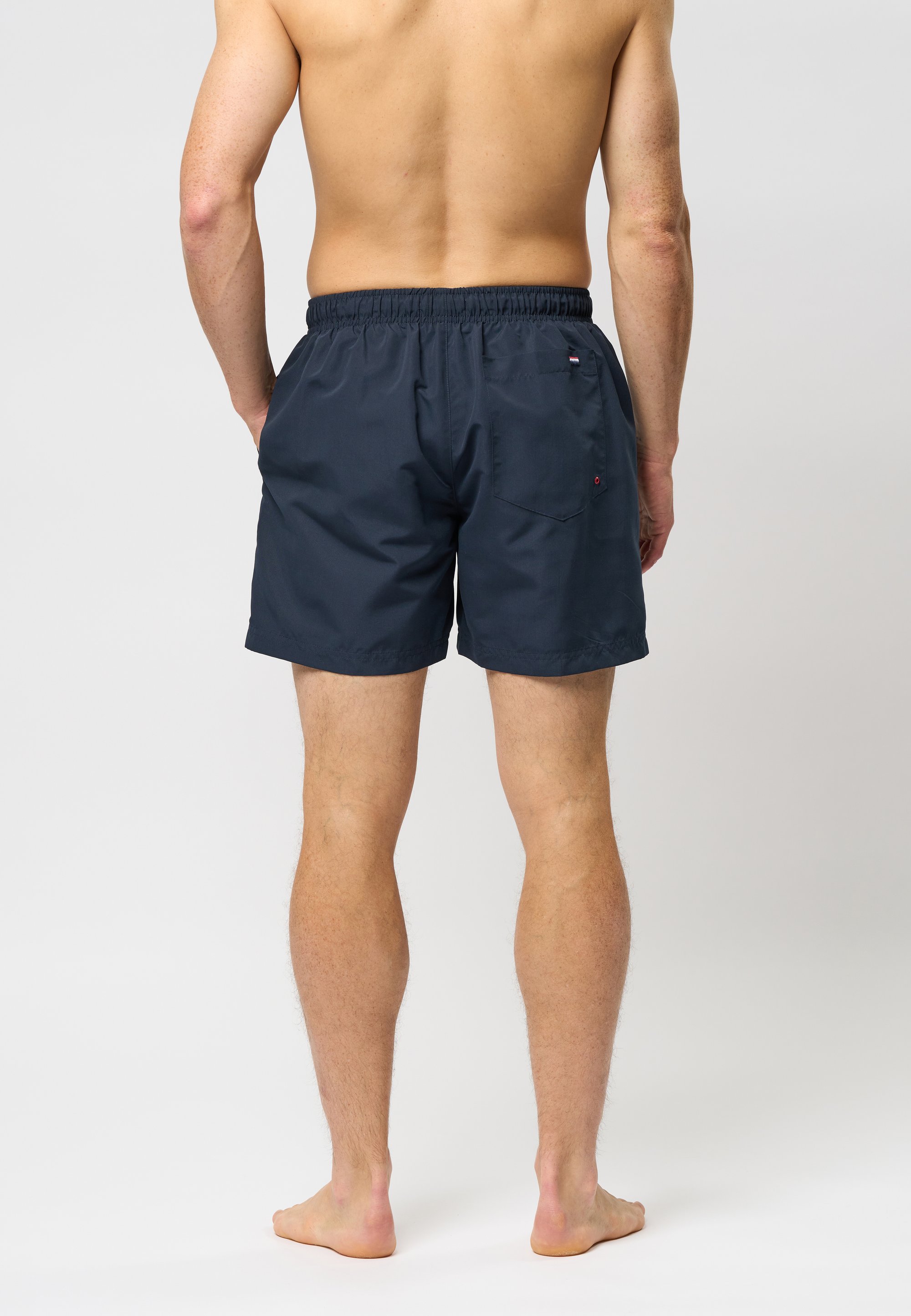 Navy blue swim shorts with an elastic waistband, two back pockets, and a small logo detail. Made from lightweight, quick-drying material.