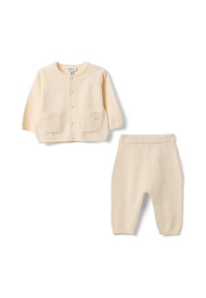 Weiche, cremefarbene Babystrickjacke mit Knöpfen und passenden Strickhosen mit elastischem Bund vor weißem Hintergrund.