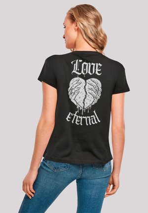 Black short-sleeve T-shirt featuring a graphic of hands forming a heart with dripping accents, text reading "Love eternal" above.