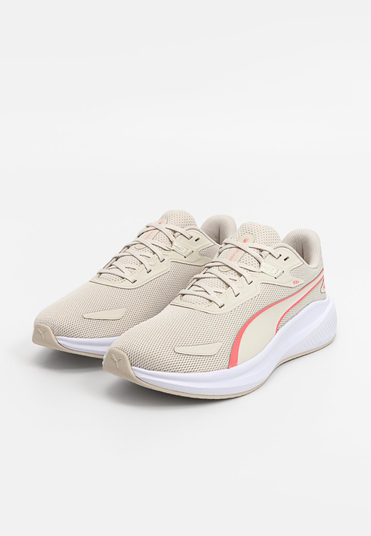 Baskets de sport beige avec une tige en maille texturée, des accents roses sur les côtés, et une semelle intermédiaire blanche. Comprend un laçage standard et un col rembourré.