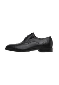 Schwarzer Leder-Dressschuh mit glatter Oberfläche, runder Zehenpartie und dekorativer Naht entlang der Seiten, auf einer niedrigen Gummisohle.