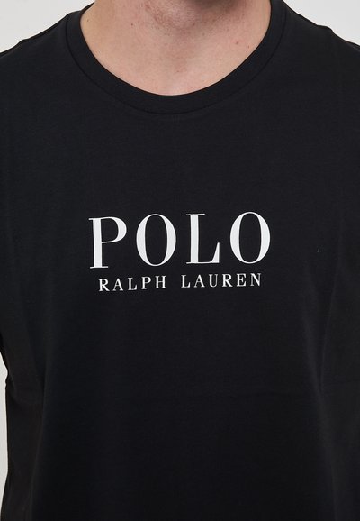 T-shirt in cotone nero con logo "POLO RALPH LAUREN" bianco. Design a maniche corte e collo rotondo. Texture morbida e liscia.