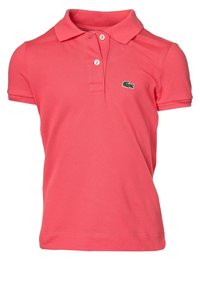 Vaaleanpunainen puuvillapaita, jossa on lyhyet hihat, kolmonen napitus ja pieni vihreä logo vasemmassa rinnassa. Rakenteellinen kangas.