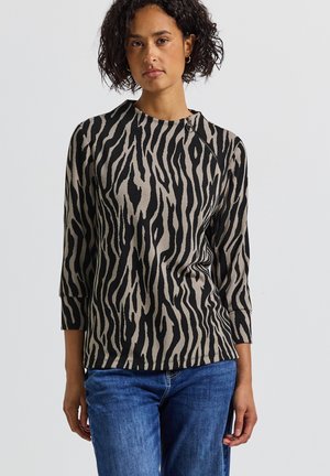 T-shirt à rayures noires et beiges à manches longues avec un col rond et une coupe décontractée. Le tissu semble doux avec une texture subtile. Détail accentué à l'épaule.