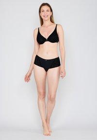 Black lingerie set featuring a triangular bra with textured velvet and matching high-waisted briefs. Notable gold accent detail on the bra.