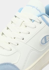 Λευκό και ανοιχτό μπλε δερμάτινο αθλητικό παπούτσι με λευκά κορδόνια, διάτρητη πλευρική επιφάνεια και κεντημένο λογότυπο "C" στην πλευρά.