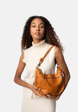Borsa a spalla in pelle di un caldo arancione, dotata di tasca con zip, finitura texture e tracolla regolabile. Il modello la tiene contro uno sfondo neutro.