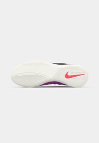 Nike apavu zole ir ar baltu teksturētu ārējo zoli, kurai ir rozā Swoosh un purpura akcents, kas izstrādāta, lai nodrošinātu saķeri un elastību.