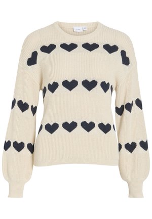 Kreemjas kootud kampsun mustade südamekujude mustriga rinnal, varrukatel ja õlgadel, pikkade läikivate varrukatega ning ümara kaelusega.