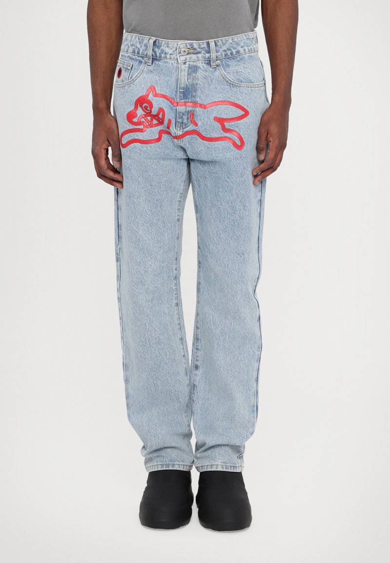 Jeans din denim de un albastru deschis cu un croi relaxed, având un mare design brodat cu un pisoi de desene animate roșu pe spate și o ușoară decolorare.