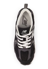 Chaussure de running noire et grise avec une tige en mesh, des lacets blancs, et une languette rembourrée. Logo notable sur le côté et semelle en caoutchouc texturée.