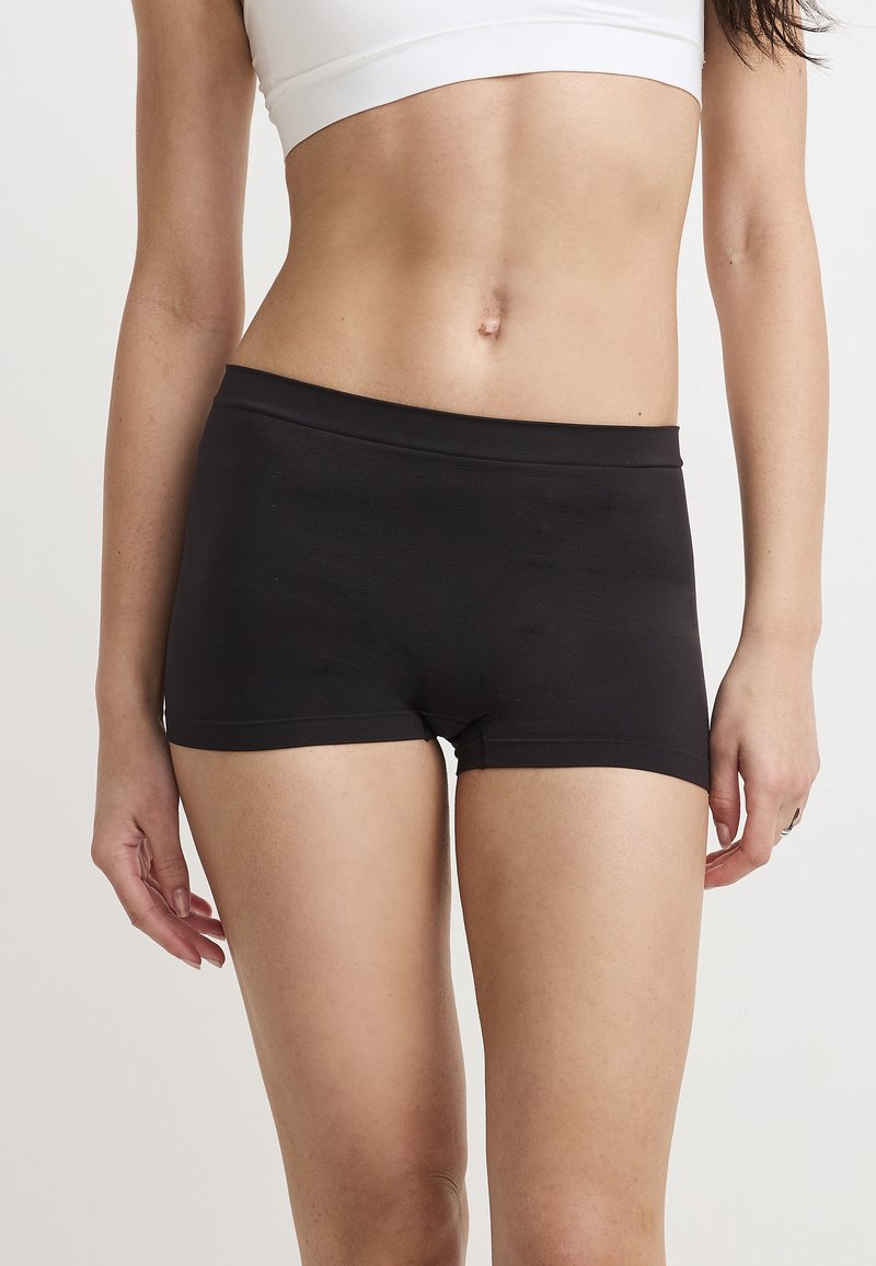 Schwarze Baumwollmischung-Shorts mit glatter Textur, mittelhohem Bund und kurzem Bein, präsentiert auf einem neutralen Hintergrund.