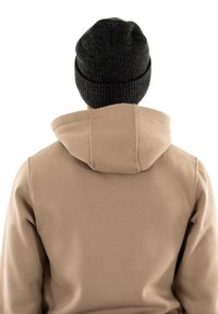 Sudadera beige con una gran capucha, textura suave y gorro de punto negro acanalado. Vista desde la parte de atrás, sin logotipos ni patrones visibles.
