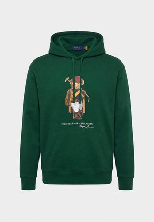 Sötétzöld kapucnis pulóver elülső zsebbel, amelyen egy Polo medve látható poloöltözetben, alatta a "Polo Bear by Ralph Lauren" felirattal.