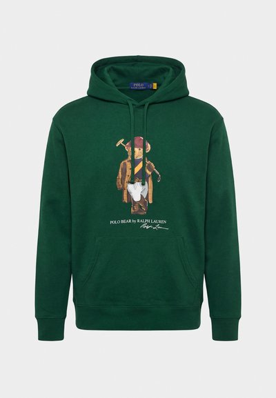 Temno zelena obleka s kapuco in sprednjim žepom, z motivom medveda Polo v polo oblačilih ter napisom "Polo Bear by Ralph Lauren" spodaj.