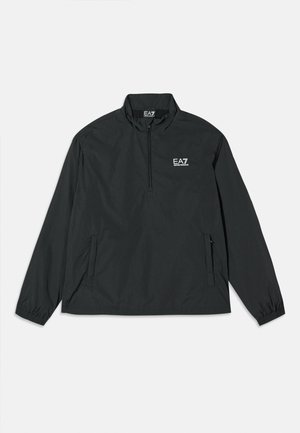 Pulloverjakke i svart, lett stoff med halv-zip lukking, lange ermer, elastiske mansjetter og sidelommer. Har EA7-logo på brystet.