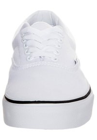 Witte canvas sneakers met ronde neus, zes eyelets en witte veters. Bevat een dunne zwarte accenten nabij de zool. Textuur rubberen outsole.