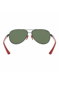 Occhiali da sole aviatori con lenti verdi, montatura in metallo nero e punte delle aste in gomma rossa. Presentano naselli regolabili per il massimo comfort.