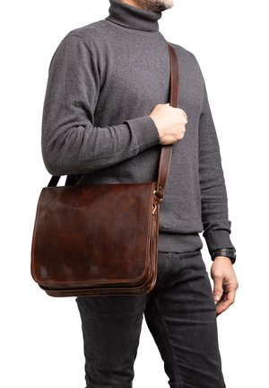 Sac messager en cuir marron avec une texture lisse, une forme plate et une longue sangle réglable, porté en bandoulière.