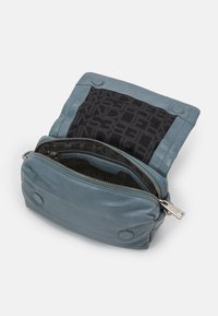 Borsa di pelle azzurro chiaro con apertura con zip. Caratterizzata da un interno a fantasia nera e chiusure a pulsante sul lato superiore. Design compatto e strutturato.