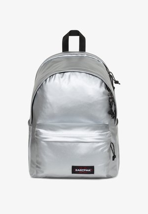 Silver backpack with a shiny, smooth texture, featuring a front pocket, adjustable black straps, and a black logo patch.