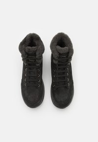 Svart nubuck høye støvler med en myk, grå fleecekrage, med metallhull, svarte lisser og en teksturert gummisåle.